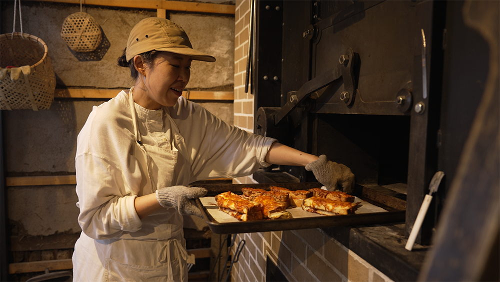 窯でパンを焼く平井さん